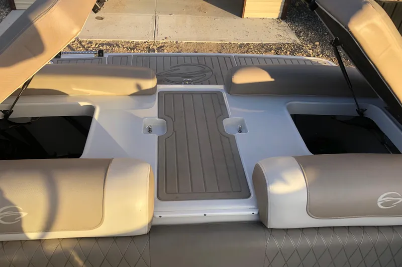 Slide: The Image of 2020 Crownline 235 SS boat interior with beige seating and storage compartments. - 34
