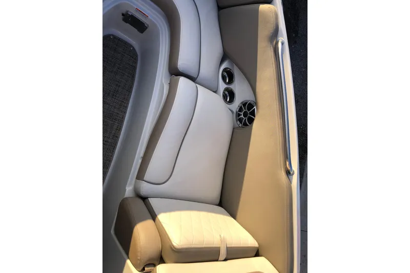 Slide: The Image of 2020 Crownline 235 SS boat interior with beige seating and built-in cup holders. - 36