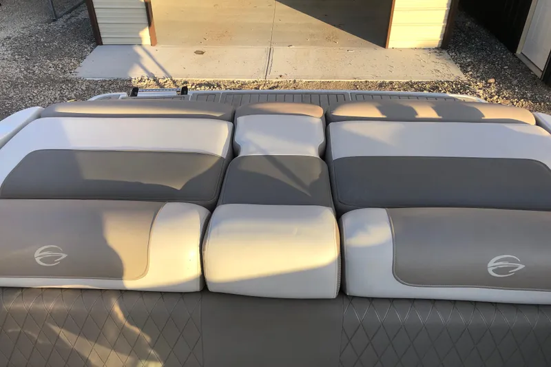 Slide: The Image of 2020 Crownline 235 SS boat interior with cushioned seating in beige and gray tones. - 38