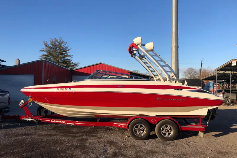 Slide: The Image of 2020 Crownline 235 SS boat in red and white on a trailer. - 8