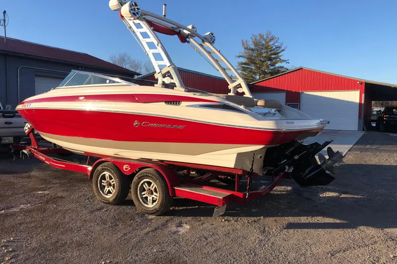 Slide: The Image of 2020 Crownline 235 SS boat on trailer, red and white, parked outdoors. - 9