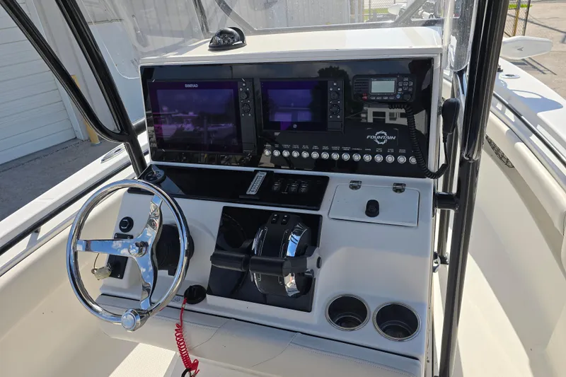 Slide: The Image of 2006 Fountain 23 Center Console boat dashboard with steering wheel and navigation controls. - 11