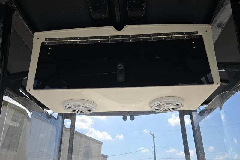 Slide: The Image of 2006 Fountain 23 Center Console boat speakers and storage compartment under clear sky. - 12
