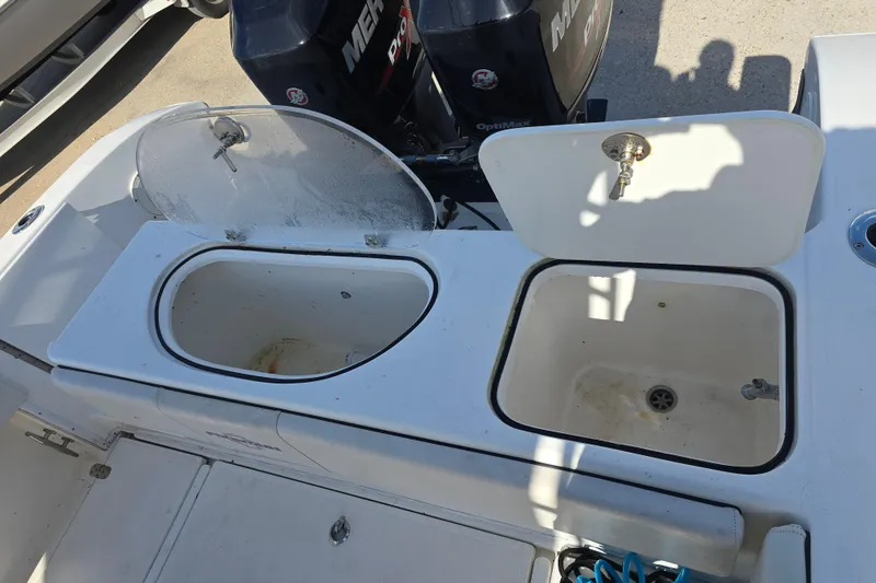 Slide: The Image of 2006 Fountain 23 Center Console boat with open storage compartments and Mercury engines. - 14