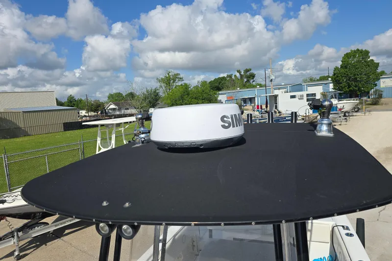 Slide: The Image of 2006 Fountain 23 Center Console boat with radar, parked outdoors under a blue sky. - 22