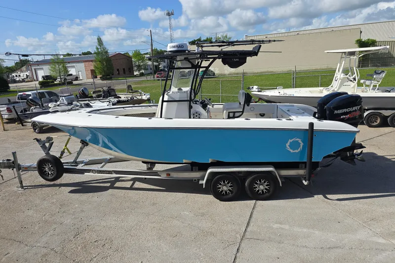 Slide: The Image of 2006 Fountain 23 Center Console boat on trailer, blue hull, parked outdoors under a clear sky. - 6
