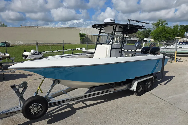 Slide: The Image of 2006 Fountain 23 Center Console boat on trailer, parked outdoors under cloudy sky. - 9