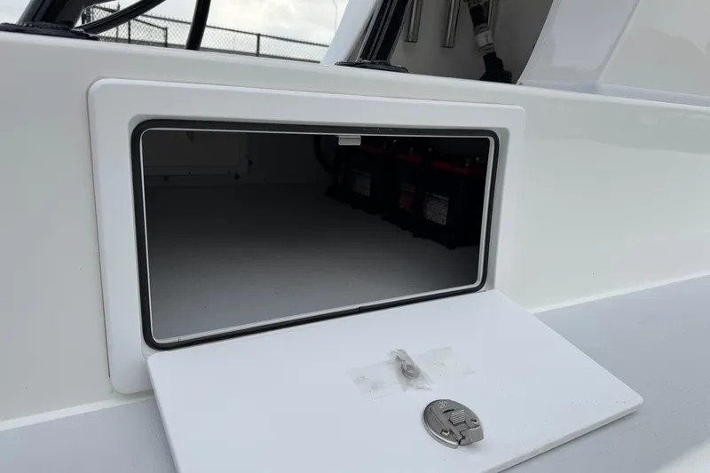 Slide: The Image of 2026 Shallow Sport 22 Sport boat storage compartment with visible battery setup. - 11