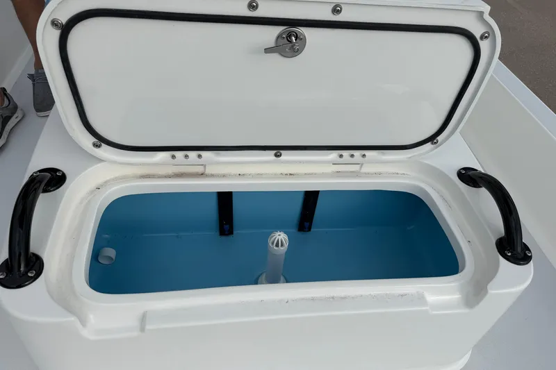 Slide: The Image of Open storage compartment on 2026 Shallow Sport 22 Sport boat, featuring blue interior. - 18