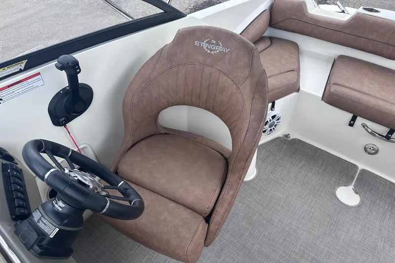 Slide: The Image of 2022 Stingray 201 DC boat interior with brown seating and steering wheel. - 10