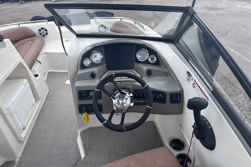 Slide: The Image of 2022 Stingray 201 DC boat dashboard with steering wheel and controls. - 12