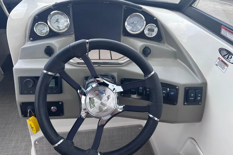 Slide: The Image of 2022 Stingray 201 DC boat dashboard with steering wheel and gauges. - 13