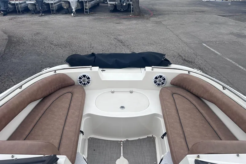 Slide: The Image of 2022 Stingray 201 DC boat interior with brown seating and speakers. - 19