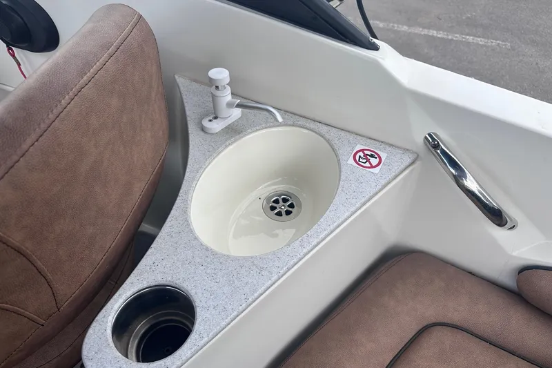 Slide: The Image of 2022 Stingray 201 DC boat interior with sink and cup holder. - 8