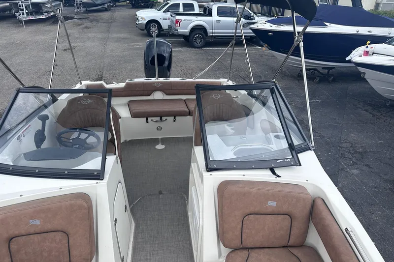 Slide: The Image of 2022 Stingray 201 DC boat interior with tan seating and steering wheel. - 9