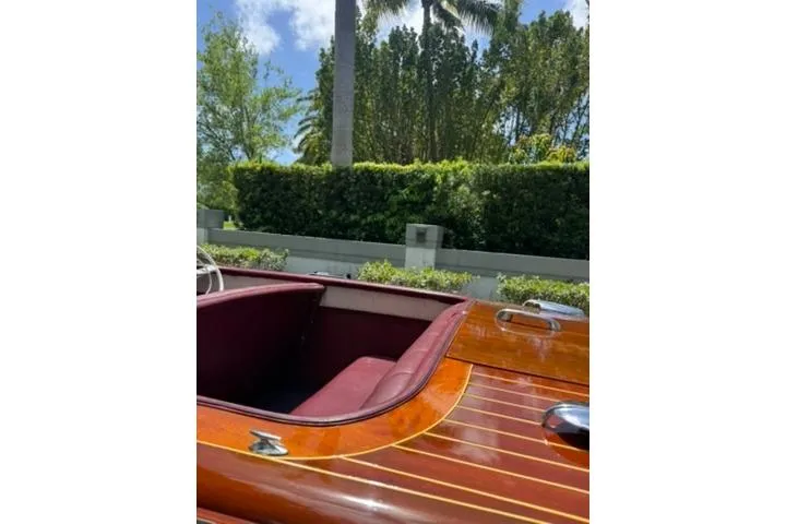 Slide: The Image of 1952 Chris-Craft 18 Runabout with polished wood finish and maroon interior, outdoors. - 14