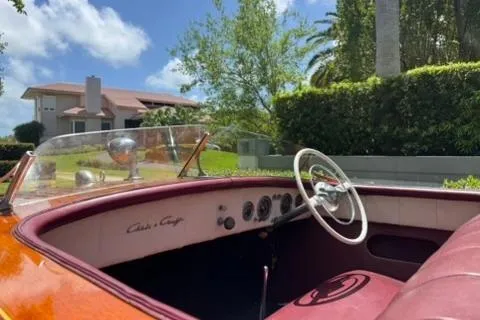 Slide: The Image of 1952 Chris-Craft 18 Runabout boat with vintage dashboard and steering wheel, parked outdoors. - 16