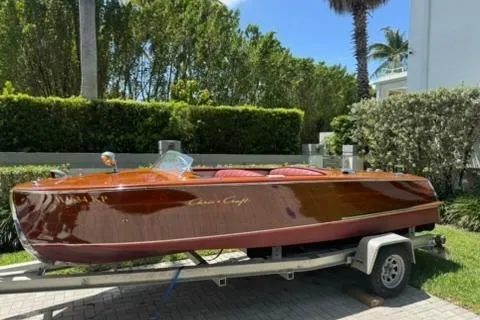 Slide: The Image of 1952 Chris-Craft 18 Runabout boat on trailer, surrounded by lush greenery. - 3