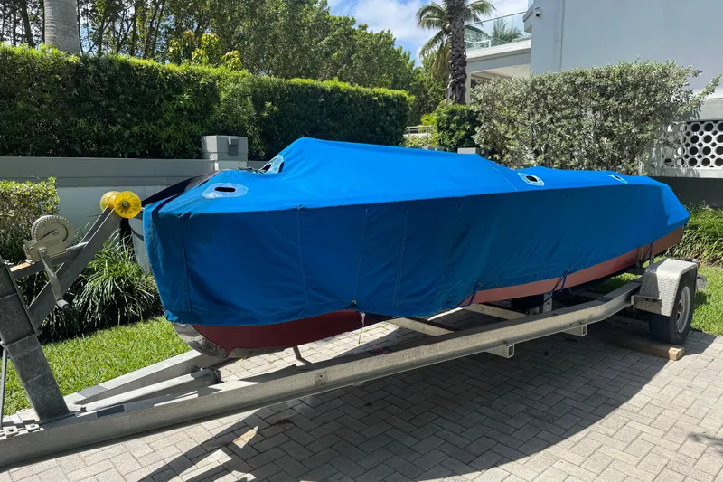 Slide: The Image of 1952 Chris-Craft 18 Runabout covered on trailer, parked outdoors. - 36