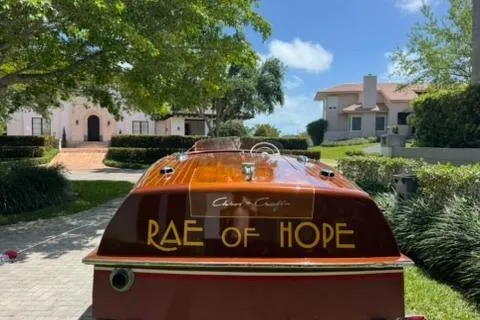 Slide: The Image of 1952 Chris-Craft 18 Runabout boat named "Rae of Hope" parked outdoors. - 4