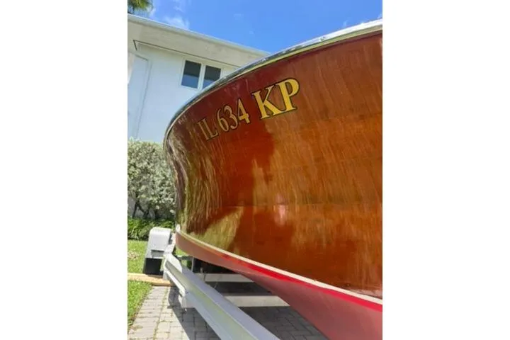 Slide: The Image of 1952 Chris-Craft 18 Runabout boat with wooden hull on a trailer, sunny day. - 7