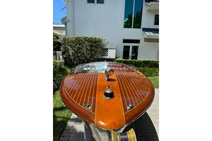 Slide: The Image of 1952 Chris-Craft 18 Runabout with polished wooden deck, parked outdoors. - 8