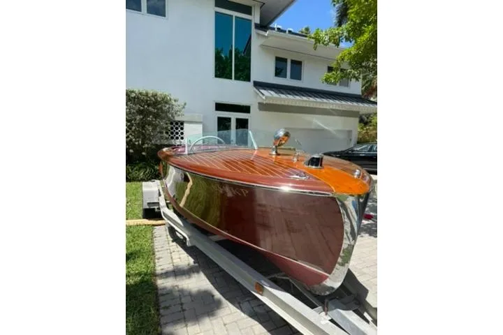 Slide: The Image of 1952 Chris-Craft 18 Runabout boat on trailer, parked in front of modern house. - 9