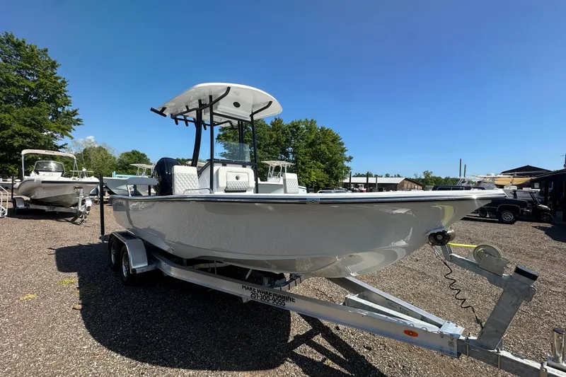 Slide: The Image of 2026 Action Craft 22 Bay boat on trailer, parked outdoors under clear blue sky. - 11