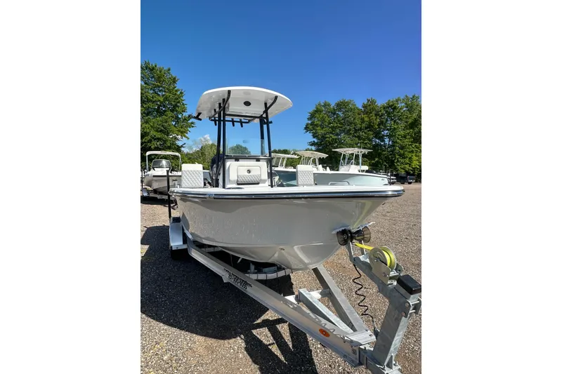 Slide: The Image of 2026 Action Craft 22 Bay boat on trailer, parked outdoors under clear blue sky. - 12