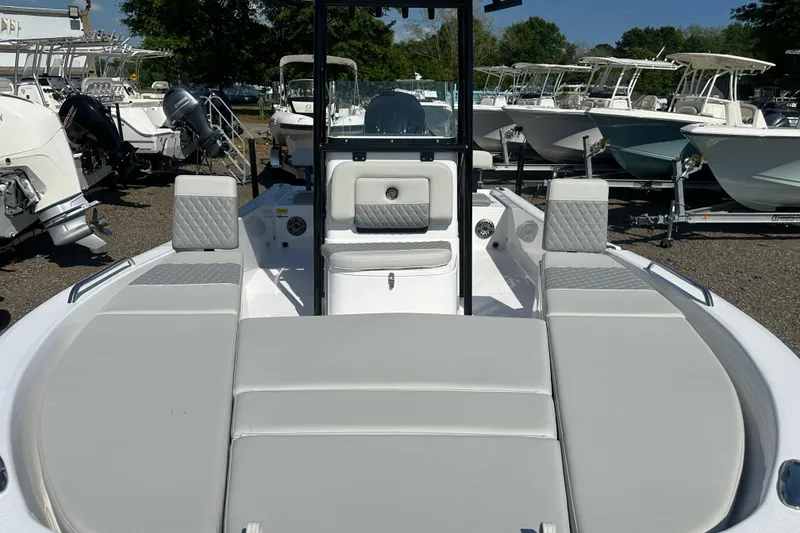 Slide: The Image of 2026 Action Craft 22 Bay boat interior with cushioned seating, parked among other boats. - 13