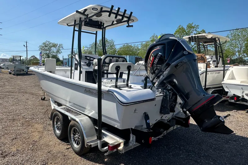 Slide: The Image of 2026 Action Craft 22 Bay boat with outboard motor on trailer, parked outdoors. - 4