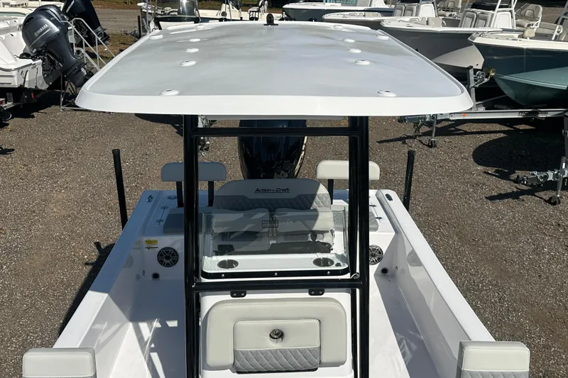 Slide: The Image of 2026 Action Craft 22 Bay boat with T-top and center console, parked on gravel. - 46