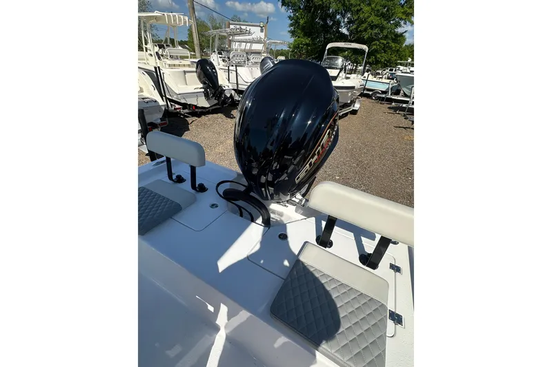 Slide: The Image of 2026 Action Craft 22 Bay boat with outboard motor and seating, displayed outdoors. - 48