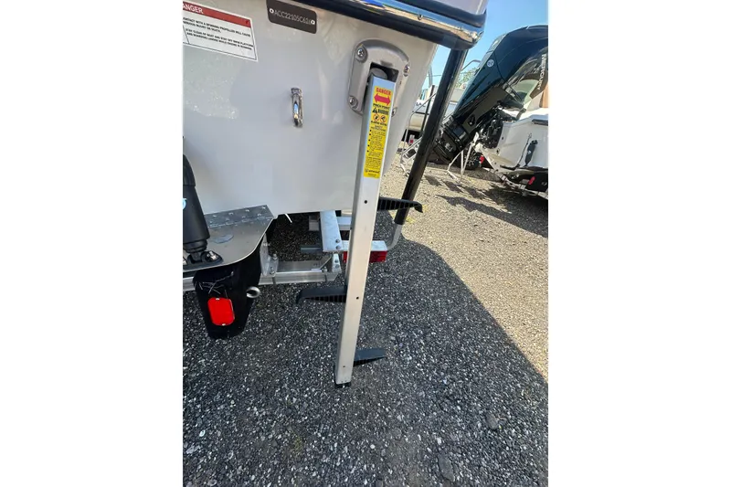 Slide: The Image of 2026 Action Craft 22 Bay boat trailer detail with safety warning label. - 8