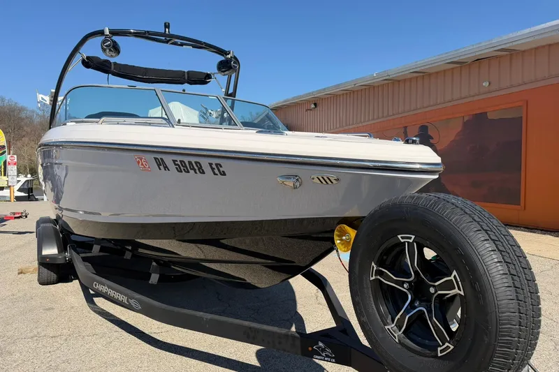 Slide: The Image of 2023 Chaparral 23 SSi boat on trailer, parked outdoors under clear blue sky. - 2