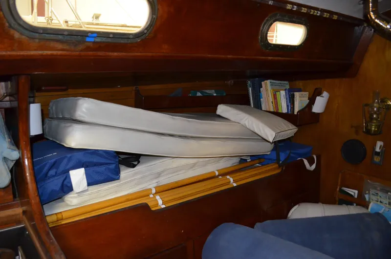 Slide: The Image of Interior of a 1963 Hinckley Bermuda 40 with stacked mattresses and wooden paneling. - 10