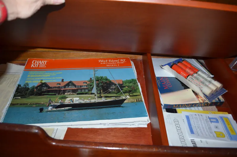 Slide: The Image of Navigation charts and accessories in a drawer on the 1963 Hinckley Bermuda 40. - 27