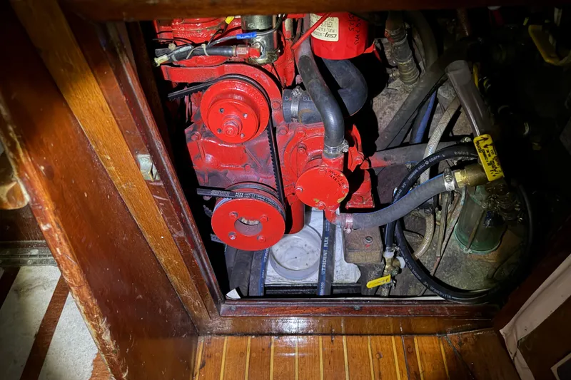 Slide: The Image of Engine compartment of a 1963 Hinckley Bermuda 40 sailboat, featuring red mechanical components. - 32