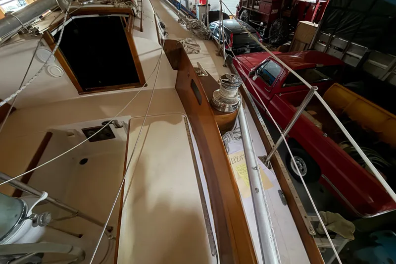 Slide: The Image of 1963 Hinckley Bermuda 40 sailboat deck in storage, alongside vintage red truck. - 49