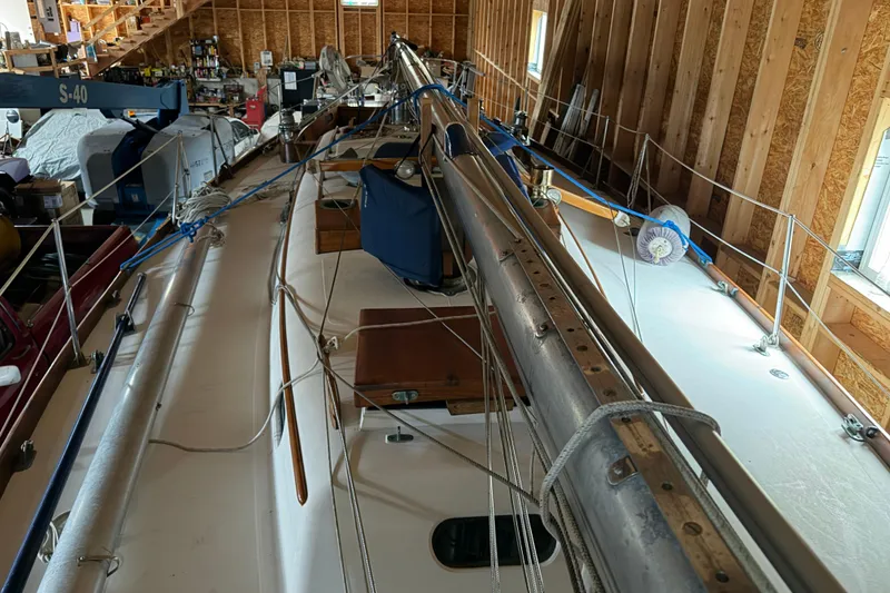 Slide: The Image of 1963 Hinckley Bermuda 40 sailboat in a wooden workshop, mast and rigging visible. - 53