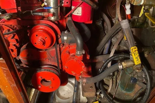 Slide: The Image of Engine compartment of a 1963 Hinckley Bermuda 40 sailboat, featuring red mechanical components. - 63