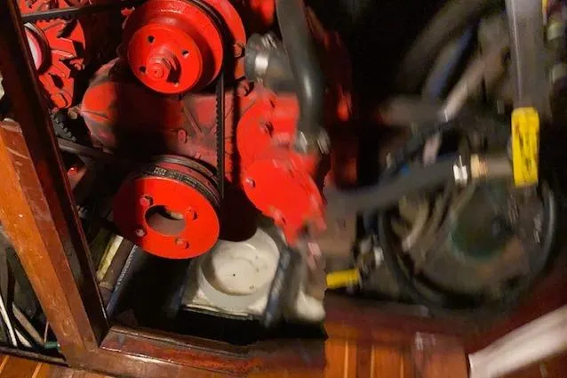Slide: The Image of Engine compartment of a 1963 Hinckley Bermuda 40 sailboat, featuring red mechanical components. - 68