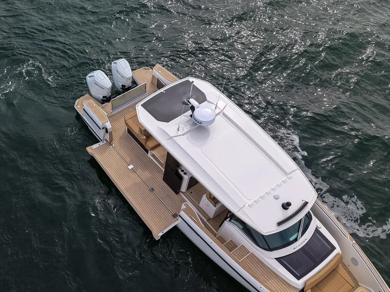 Slide: The Image of The image shows a 2027 Saxdor 400 GTS boat on the water. It features a modern design with twin outboard engines and a spacious deck. - 32