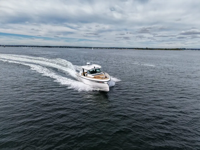 Slide: The Image of A 2027 Saxdor 400 GTS speeds across the water under a cloudy sky. - 28