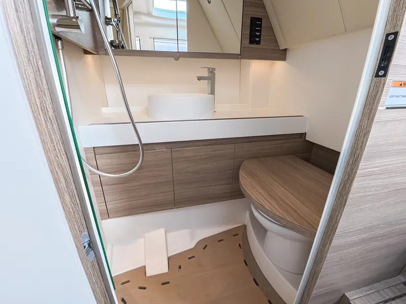 Slide: The Image of The image shows a modern boat bathroom with wood paneling and a sink. - 25