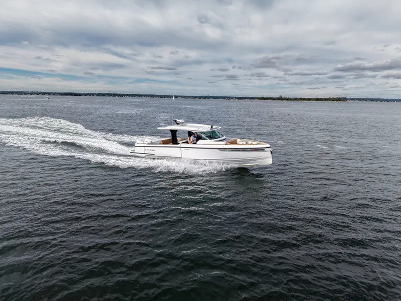 Slide: The Image of A 2027 Saxdor 400 GTS speeds across the water under a cloudy sky. - 27