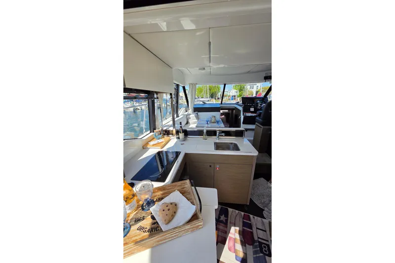 Slide: The Image of Interior of 2024 Jeanneau NC Weekender 1295 Fly, featuring modern kitchen and dining area. - 14