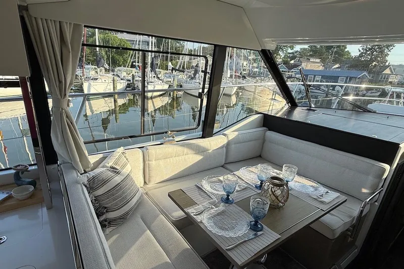Slide: The Image of Interior of 2024 Jeanneau NC Weekender 1295 Fly with elegant dining setup and marina view. - 15