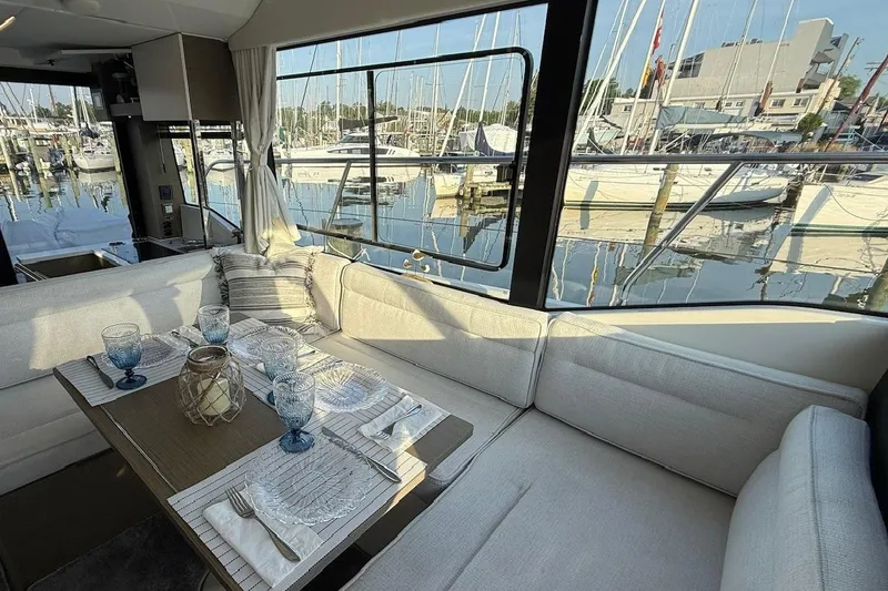 Slide: The Image of Interior of 2024 Jeanneau NC Weekender 1295 Fly with elegant dining setup and marina view. - 16
