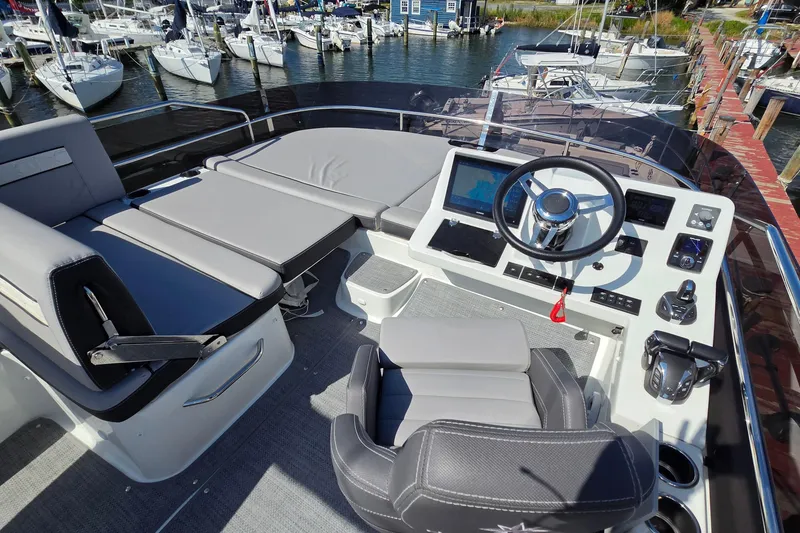 Slide: The Image of 2024 Jeanneau NC Weekender 1295 Flybridge with modern helm and seating, docked at marina. - 8